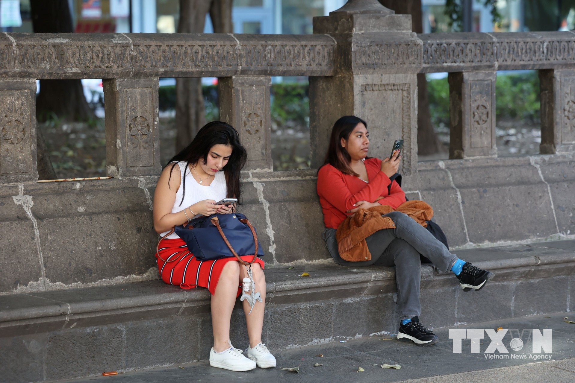 Người dân sử dụng điện thoại di động tại trung tâm thủ đô Mexico City. (Ảnh: Phi Hùng/TTXVN)